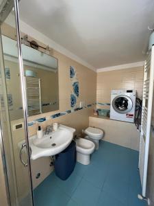 een badkamer met een wastafel, een toilet en een wasmachine bij Casa Levante Gallipoli in Gallipoli