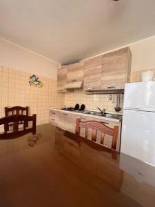 een keuken met een witte koelkast en houten kasten bij Casa Levante Gallipoli in Gallipoli