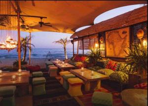 馬貝拉的住宿－Modern 2 bedroom in Marbella Real，海滩上的餐厅,配有桌椅