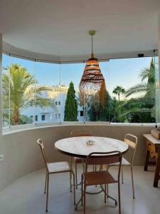 馬貝拉的住宿－Modern 2 bedroom in Marbella Real，配有大窗户的客房内的桌椅