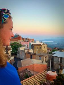 Eine Frau, die auf einem Dach steht und eine Stadt ansieht. in der Unterkunft B&b Boladina Experience in Baunei