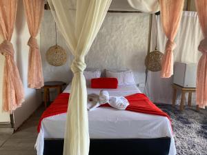 - une chambre dotée d'un lit avec des draps rouges et blancs dans l'établissement Cabaña Bambú Noche De Luna, à Jardín