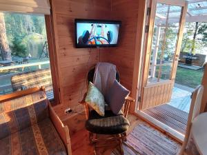 a screened in porch with a tv and a chair at Lakeside Lea, rantamökki 