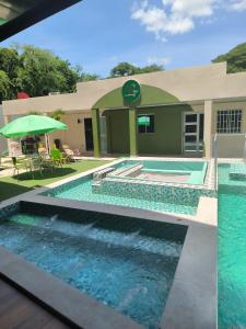 a swimming pool in front of a building at Villa campestre Meqo in Ríohacha