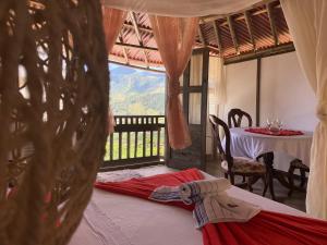 a room with a bed and a table and a window at Cabaña Bambú Noche De Luna in Jardin
