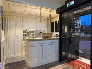a woman sitting at a counter in a kitchen at Hotel Autoespresso Venice - Atika & Atif in Marghera