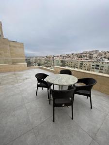 a table and chairs on the roof of a building at Luxurious Rooftop Appartment in Amman