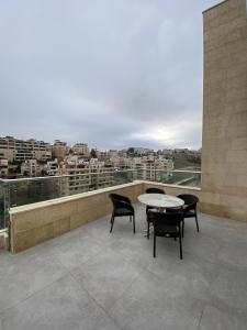 a balcony with a table and chairs and a view at Luxurious Rooftop Appartment in Amman