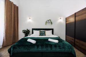 a bedroom with a large bed with a green blanket at SPAYA JACUZZI centrum apartment - with home cinema & private parking in Košice
