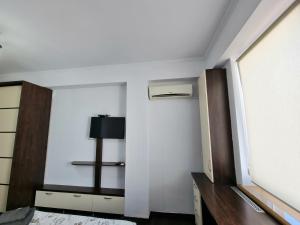 a room with a white wall with a door and a tv at Testemiteanu 1 bedroom apartment with work zone in Chişinău