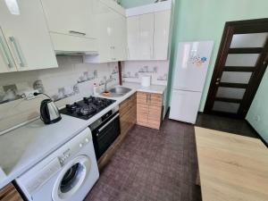 a kitchen with a stove and a washing machine at Testemiteanu 1 bedroom apartment with work zone in Chişinău