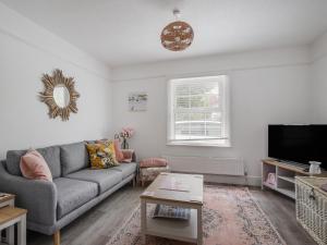 a living room with a couch and a tv at River Lym Cottage in Lyme Regis