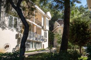 un immeuble d'appartements avec un balcon et des arbres dans l'établissement Nicholas Apartment Ölüdeniz, à Fethiye