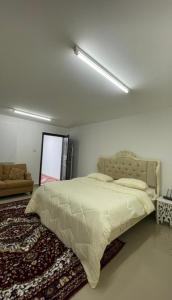 um quarto com uma cama grande e um sofá em استراحة المسافر em Al Ain