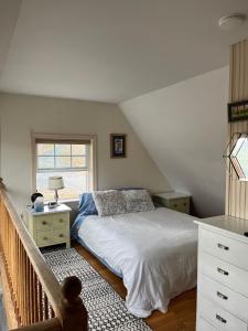 a bedroom with a white bed and a window at Not-so-tiny, Tranquil, Pond front Bungalow in Canaan