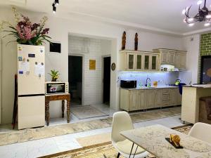 een keuken met een koelkast en een tafel en stoelen bij Duplex 80A in Tasjkent