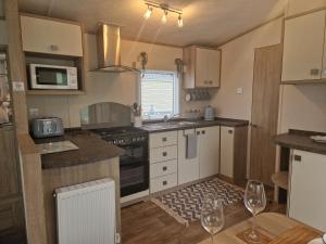 uma cozinha com um lavatório e um fogão forno superior em 18 Rannoch em Forfar