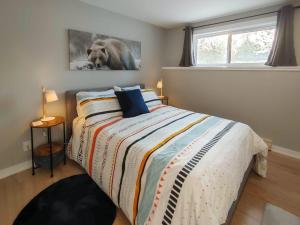 a bedroom with a bed and a picture of a dog at Chalet Escapade Orford in Orford