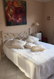 ein Schlafzimmer mit einem weißen Bett mit Kissen darauf in der Unterkunft Appartement chaleureux proche de la croisette in Cannes