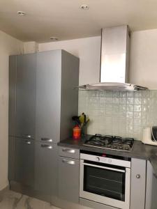 eine Küche mit einem Herd und einem Kühlschrank aus Edelstahl in der Unterkunft Appartement chaleureux proche de la croisette in Cannes