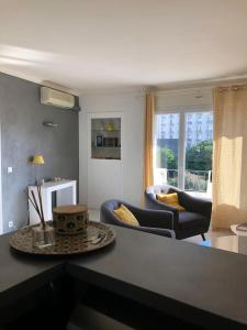 ein Wohnzimmer mit einem Sofa, Stühlen und einem Tisch in der Unterkunft Appartement chaleureux proche de la croisette in Cannes