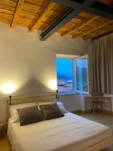 Un dormitorio con una cama y una ventana grande. en CASA MATIN BERGAMO, en Bérgamo