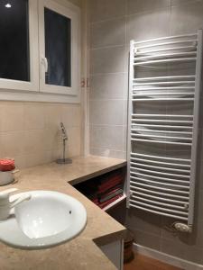 ein Badezimmer mit einem weißen Waschbecken und einer Dusche in der Unterkunft Appartement chaleureux proche de la croisette in Cannes