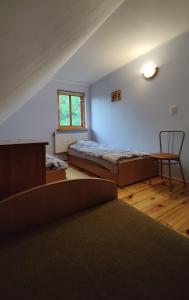 a bedroom with a bed and a desk and a chair at Wilcza Jama in Downary-Plac