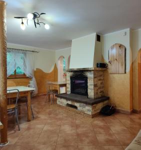 ein Wohnzimmer mit einem Steinkamin und einem Tisch in der Unterkunft Wilcza Jama 
