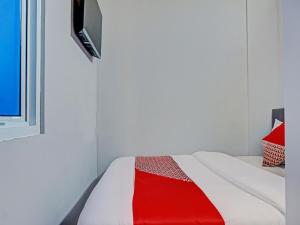 ein Bett mit einer roten und weißen Decke drauf in der Unterkunft Capital O 92765 J&b Smart Sentul in Bogor