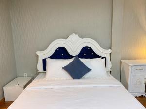 a bed with a blue and white headboard and pillows at CROWNE BUI VIEN Hotel in Ho Chi Minh City