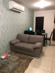 ein Wohnzimmer mit einem Sofa und einem Schreibtisch in der Unterkunft La casa azul in Culiacán Rosales
