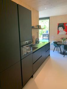 een keuken met een koelkast en een tafel. bij Villa Meijer in Almere