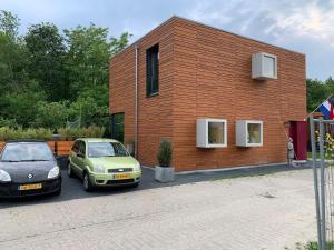 twee auto's geparkeerd voor een bakstenen gebouw bij Villa Meijer in Almere