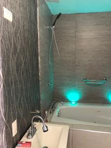 庫利亞坎的住宿－La casa azul，浴室配有水槽和绿色光浴缸。
