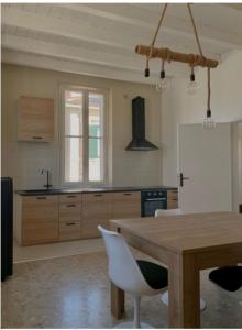 cocina con mesa de madera y nevera blanca en Casa Mare Vacanze Viale Venezia 20 Pesaro NUOVA, en Pesaro