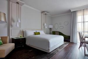 a bedroom with a white bed and a chair and a table at Charlotte Marriott SouthPark in Charlotte +47 photos