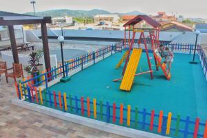 a playground with a slide and a roller coaster at Apartamento próximo a praia. in Laguna