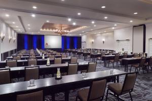 a large room with tables and chairs and a screen at Charlotte Marriott SouthPark in Charlotte
