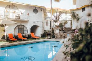 una piscina con sillas naranjas y un edificio en Hotel Ilebal en Cuernavaca