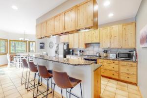 a kitchen with wooden cabinets and a bar with stools at Big Bear Palace in Fraser