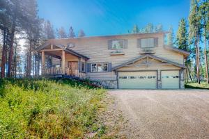 a house with two garage doors on a road at Big Bear Palace in Fraser