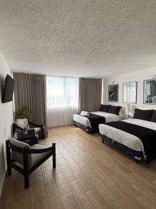 een hotelkamer met 2 bedden en een stoel bij BeachView & Balcony 3905 in Cancun