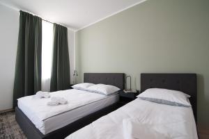 two beds sitting next to each other in a bedroom at Apartamenty Emilia in Gniezno +32 photos