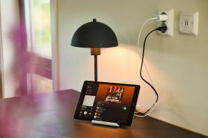 un ordinateur portable assis sur une table à côté d'une lampe dans l'établissement Lofoten panorama luxury home with sauna in Reine, à Reine
