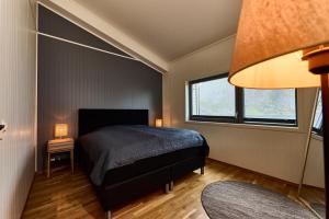 1 dormitorio con 1 cama y 2 ventanas en Lofoten panorama luxury home with sauna in Reine en Reine