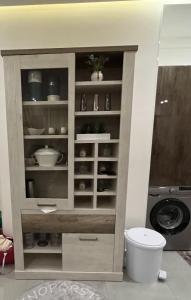 a large cabinet with dishes in it next to a washing machine at Appartement de luxe bord de Mer Essaouira à 2 pas de la plage in Essaouira +32 photos