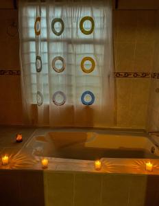 a bathroom with two candles in a bath tub at CUAJIMOLOYAS HOUSE in Cuajimoloyas