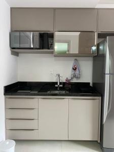 eine weiße Küche mit Spüle und Kühlschrank in der Unterkunft Itacaré Aluguel in Itacaré