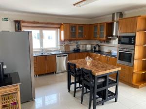 a kitchen with wooden cabinets and a table with chairs at Amazing Scorpion´s House Leiria in Leiria